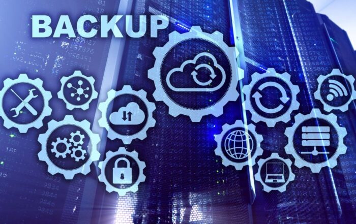 A conceptual graphic of IT servers and gears with cloud graphics, laptops, security icons and more signifying backup and business continuity.