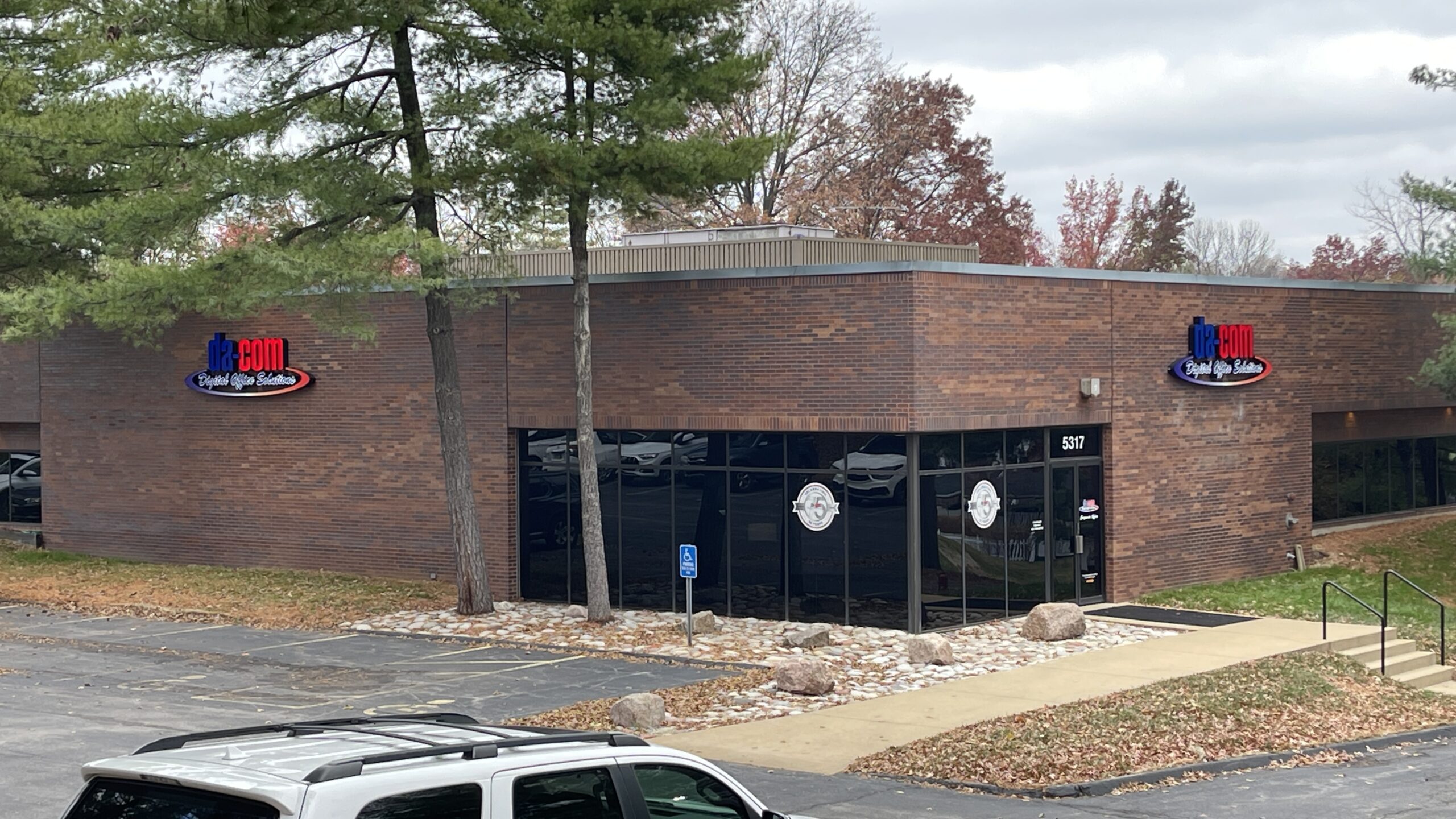 An image of the outside of Da-Com's building in St. Louis, Missouri with the logo on two corners of the brick building.